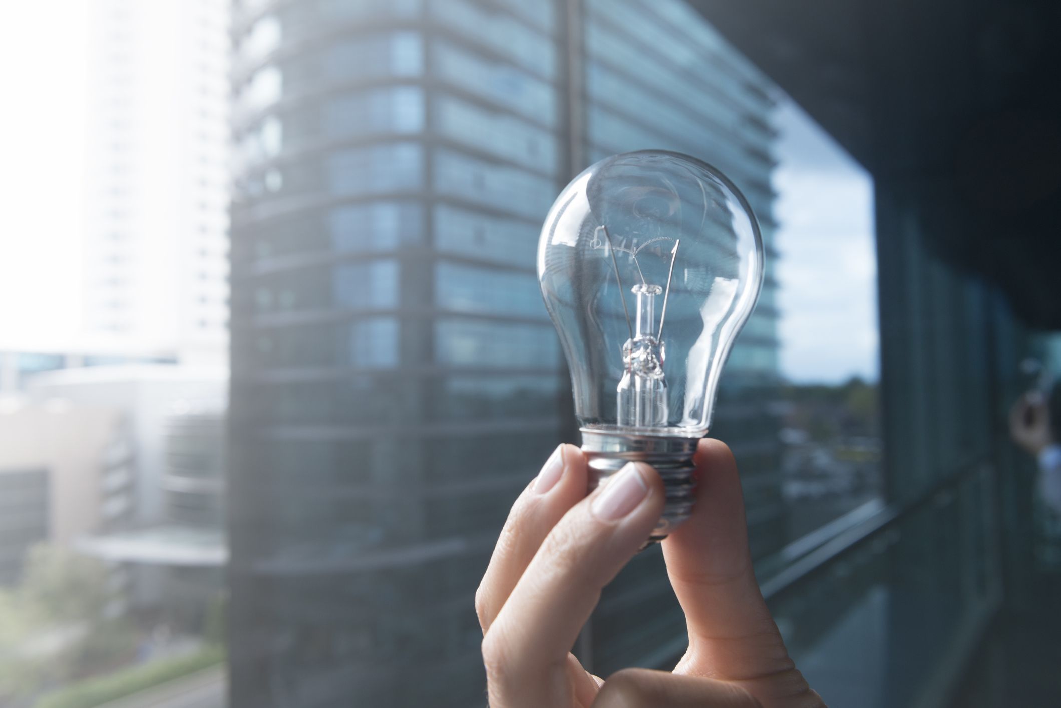 Person holding a light bulb to represent intellectual property.