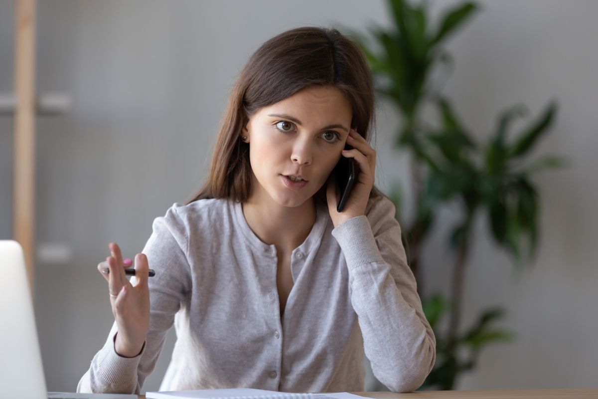 Female small business owner on phone call with a debt negotiation lawyer gettinging business debt collections advice.