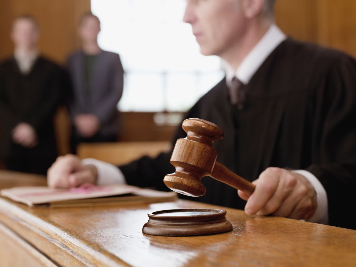 A male judge using a gavel inside a courtroom